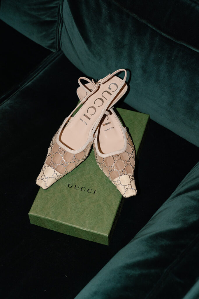 Pink Gucci bridal shoes atop a green shoebox
