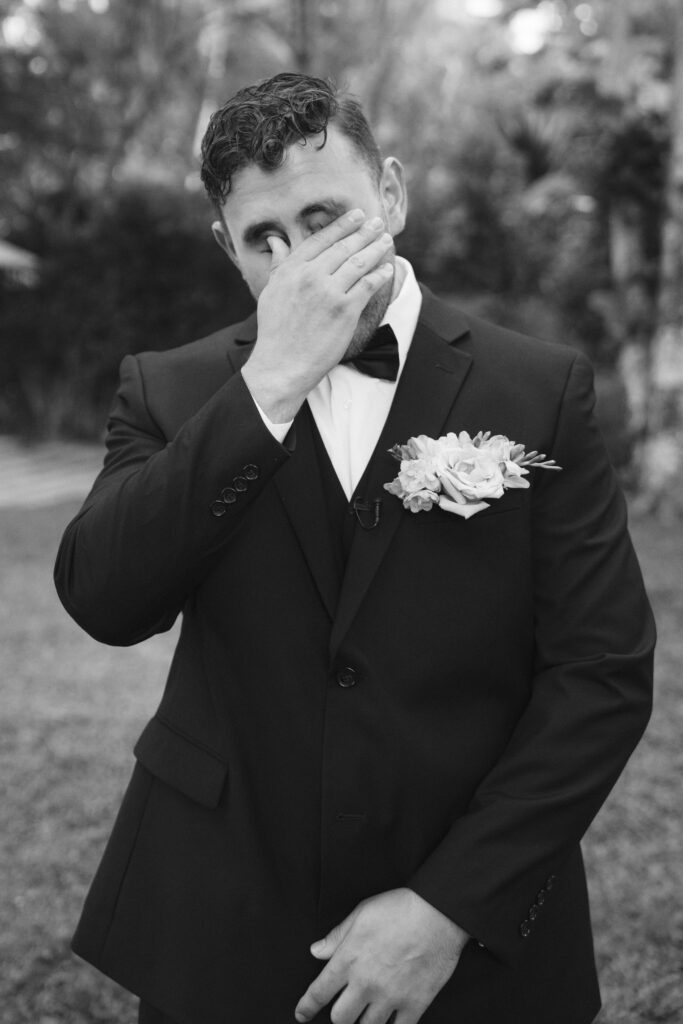 groom wiping his eyes during wedding first look
