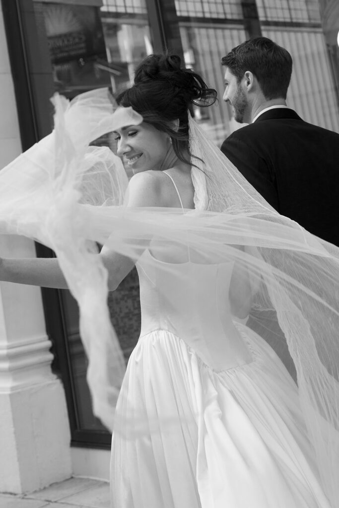 Editorial wedding photography of bride tossing veil