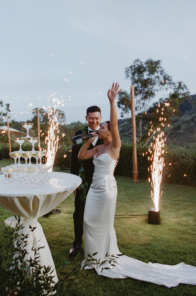 Bride and groom celebrating with champagne tower