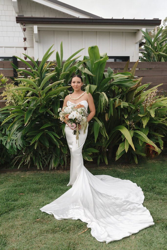 Oahu bride with long wedding gown, veil, and bridal bouquet