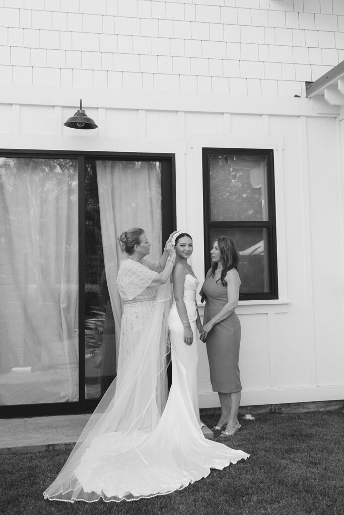 Grandma and mother-of-the-bride helping Oahu bride with wedding veil