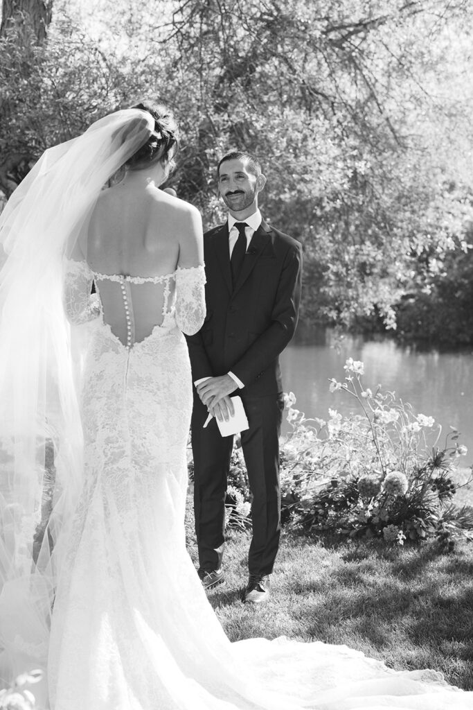 Groom watching bride read her vows at Greengate Ranch wedding ceremony