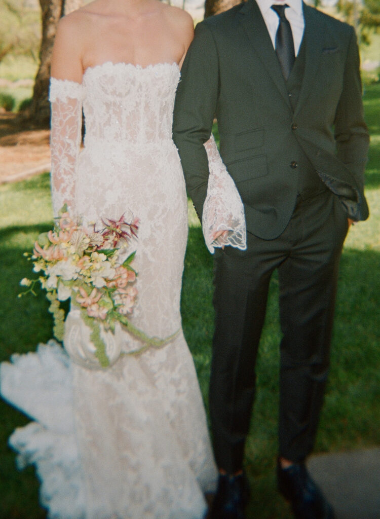 Film photo of bride and groom standing arm-in-arm