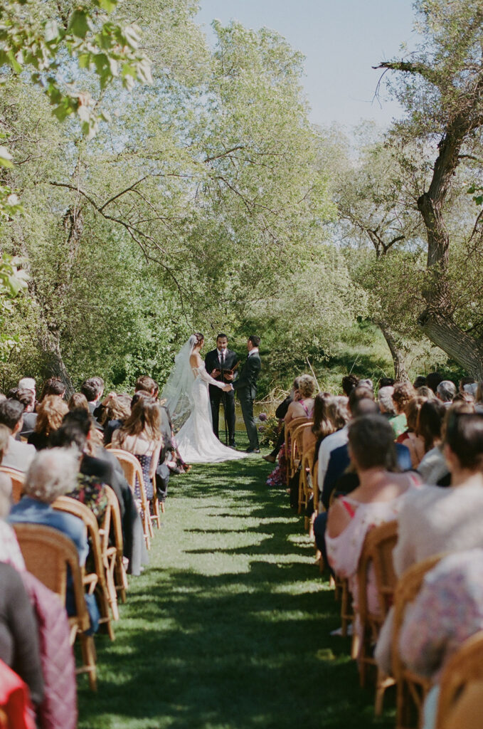 Bride and groom standing with officiant during wedding ceremony