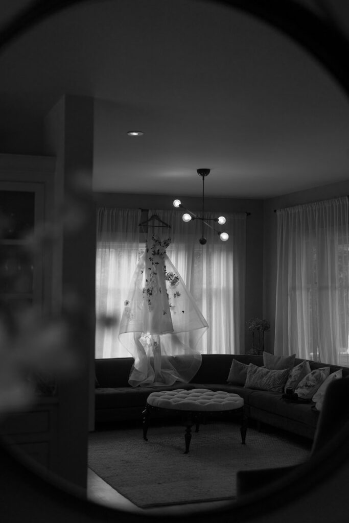 Artistic shot of bridal gown hanging in window before Sonoma wedding