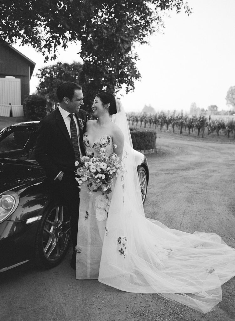 Bride and groom standing beside Porsche in Sonoma