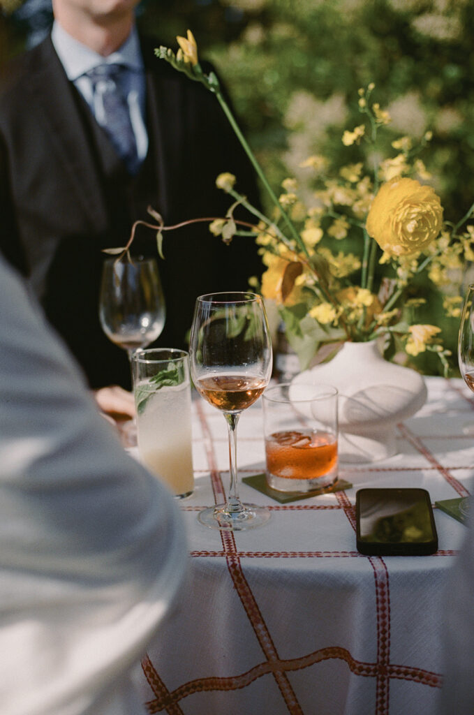 Wine and cocktail glasses on red plaid tablecloth