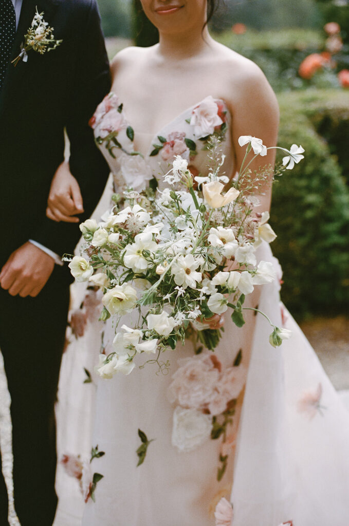 Neck-down portrait of bride holding organic bouquet