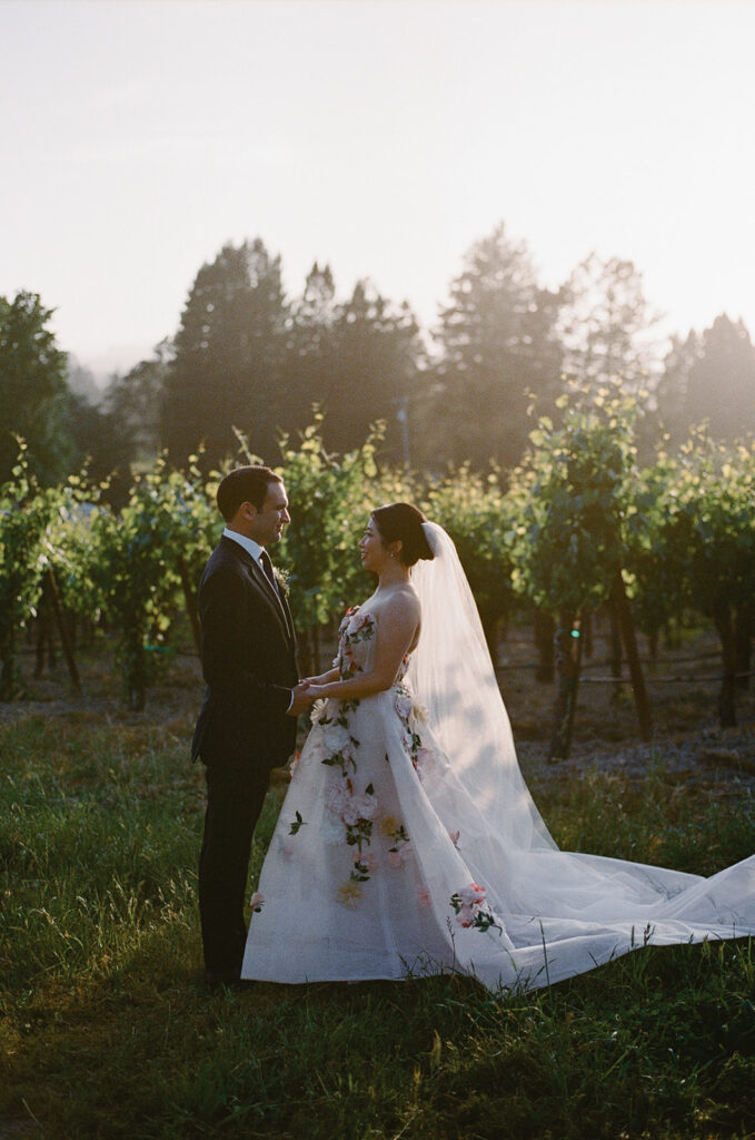 Bride and groom standing in golden light near Sonoma vineyard